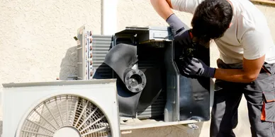 Licensed technician servicing outdoor air conditioning compressor unit in Melbourne