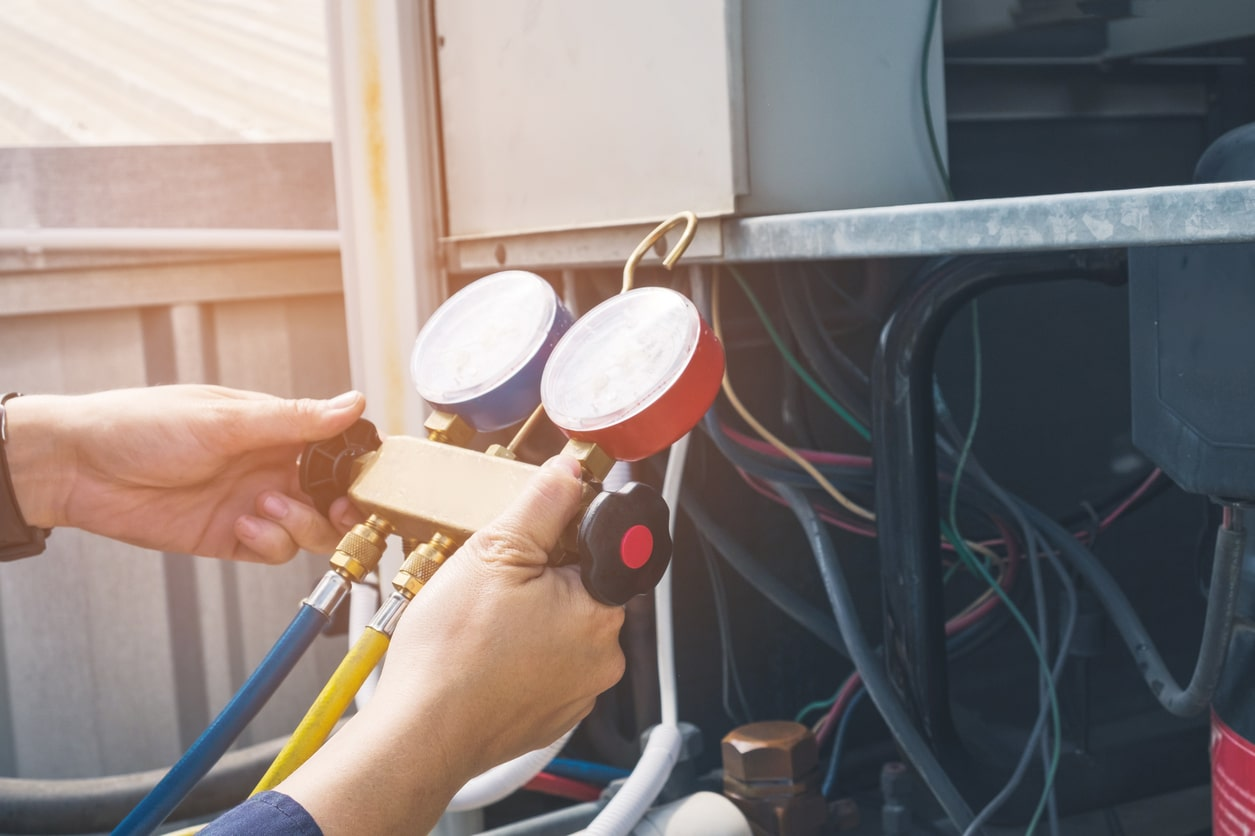 Technician using refrigerant gauges during air conditioning service in Melbourne