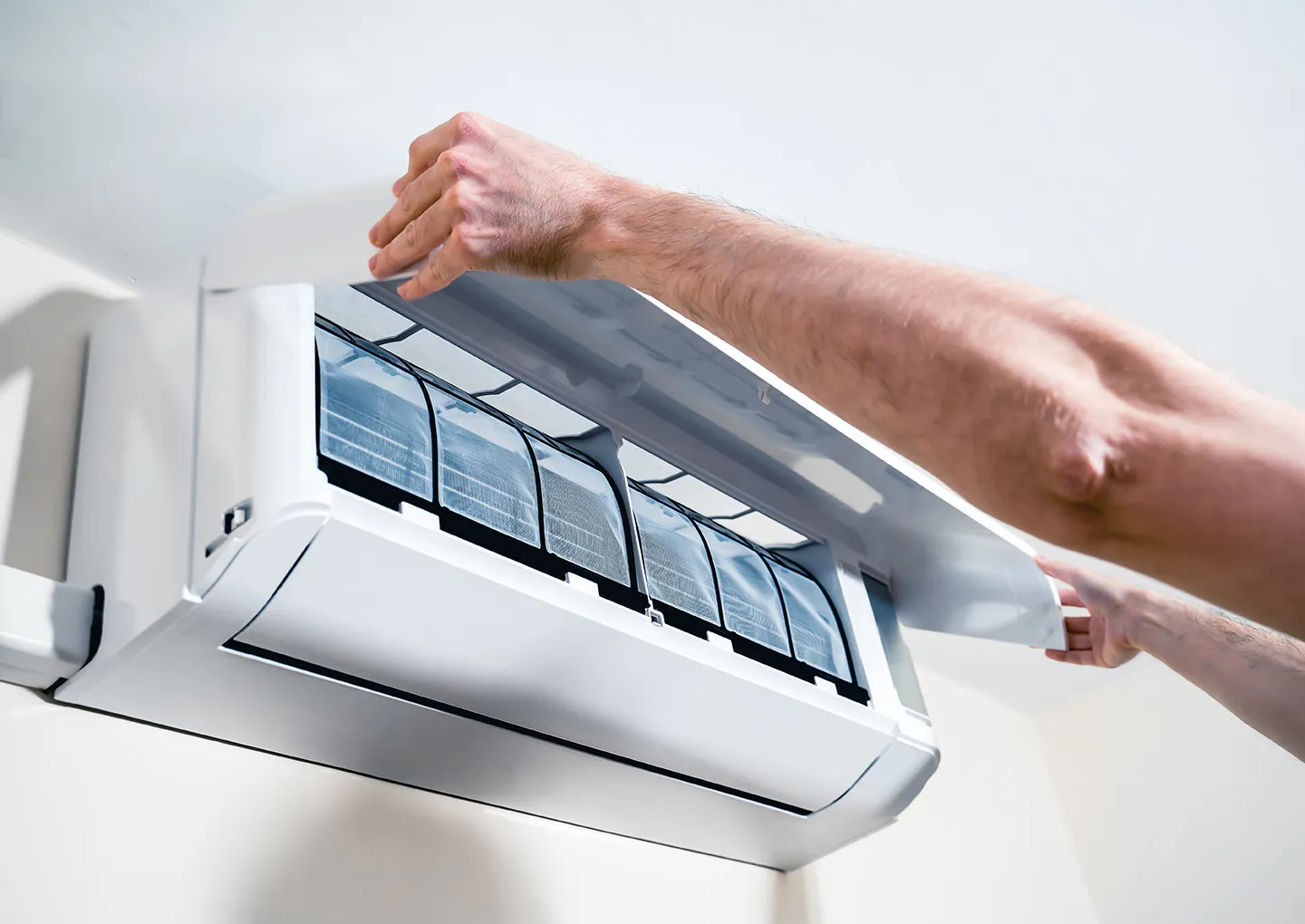 Technician opening a split system indoor unit panel for replacement service in Melbourne
